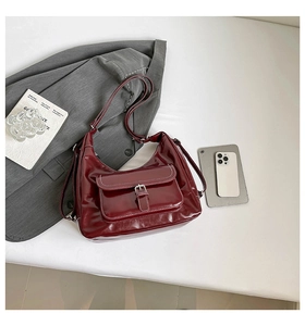 Detailed view of dark red hobo bag featuring white contrast stitching and silver buckle