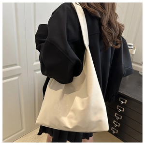 Détail d'un sac cabas minimaliste blanc crème avec texture plissée et bandoulière souple