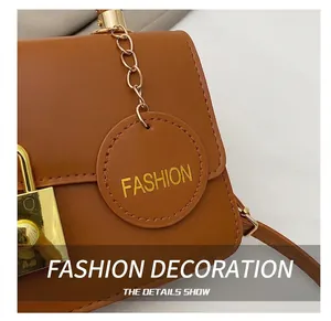 Dettaglio borsa in pelle marrone con lucchetto dorato e ciondolo rotondo Fashion