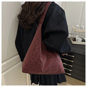 Detail of burgundy leopard print hobo tote bag worn by model showing large capacity