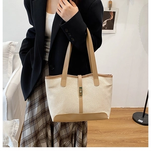 Détail du sac cabas en toile avec garniture en cuir marron et fermoir doré chic