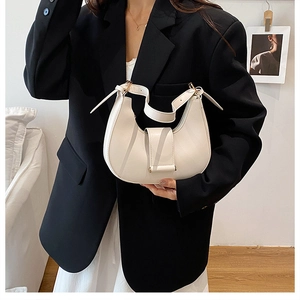 Close-up of cream leather crescent bag with elegant gold buckle and smooth texture