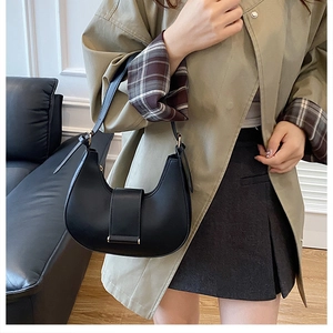 Elegant black hobo shoulder bag with buckle detail shown in a stylish lifestyle setting