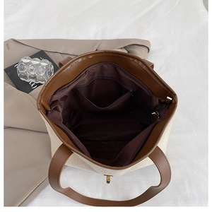 Detail view of canvas tote interior with zipper pocket and brown leather trim