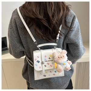 Détail du mini sac à dos en PU blanc avec motifs d'étoiles et charm d'ours en peluche