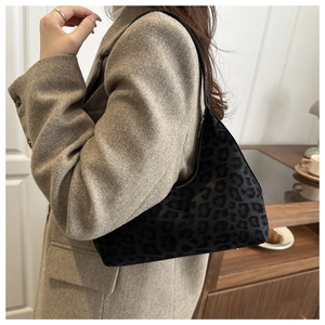 Close-up of leopard print hobo bag with FASHION metal logo on a brown wool coat