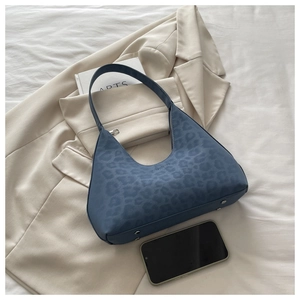Blue leopard print hobo bag with bottom studs shown next to a smartphone for scale