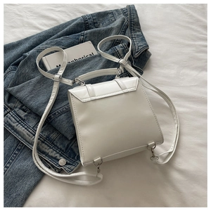 Détail du sac à dos polyvalent en cuir PU blanc sur un lit avec veste en jean