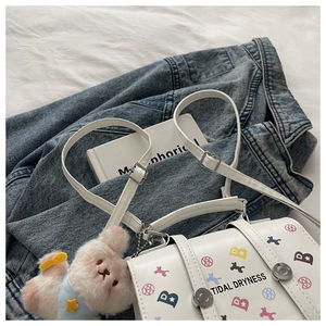 Détail du sac blanc en similicuir avec imprimés lettre B colorés et breloque lapin
