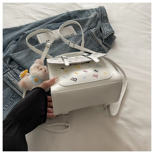 Détail du sac à dos en similicuir blanc avec imprimés cartoon et boucles argentées