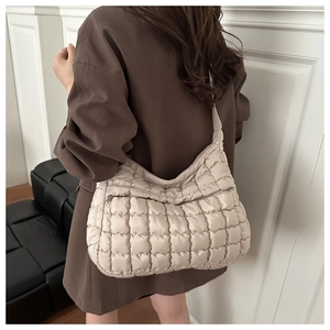 Dettaglio della borsa a nuvola trapuntata beige con tasca frontale con zip e tracolla