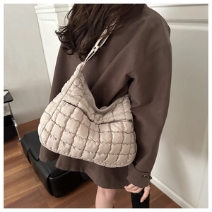 Quilted beige hobo bag with a soft puffer texture styled as a chic shoulder crossbody bag