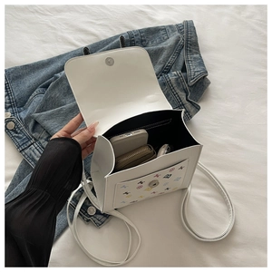 Vue intérieure du sac à rabat blanc montrant l'espace pour téléphone et maquillage