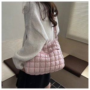 Detail of light pink quilted bubble bag showing stitching and glossy nylon texture
