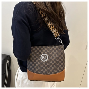 Détail du sac seau vintage avec imprimé M et large bandoulière tissée bohème