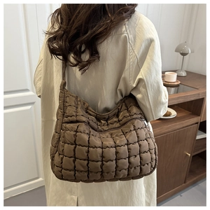 Detail of coffee brown quilted cloud bag with zipper and puffy waffle texture