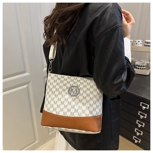 Détail du sac bandoulière avec motif monogramme et logo M métallique sur modèle