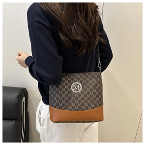 Detail of the monogram pattern and metallic M logo on the leather crossbody bag