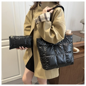 Detail der schwarzen gesteppten Puffer-Tasche und passendes Set mit glänzender Nylon-Textur
