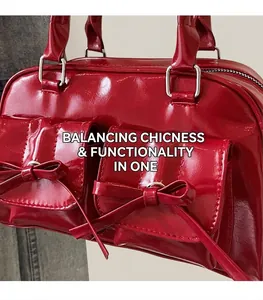 Detail of red patent leather handbag with bow accents and glossy mirror finish