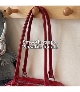Detail of red patent leather shoulder bag with glossy finish and silver metal ring strap