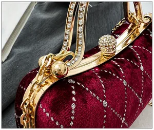 Detailed close-up of velvet evening bag with diamond ball clasp and gold crystal handle