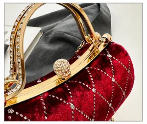 Close-up of a burgundy velvet clutch with silver mesh and a diamond-studded ball clasp