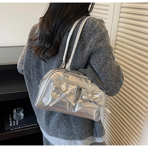 Detail of silver metallic shoulder bag featuring bow pockets and Y2K balletcore style
