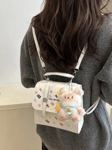 Mini sac à dos blanc à motifs étoiles avec peluche lapin sur pull gris chiné