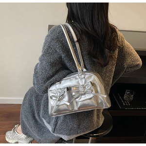 Detail of silver metallic balletcore bag featuring 3D bow pockets and dual shoulder straps