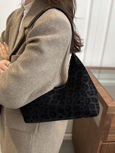 Minimalist black leopard print shoulder bag with embossed texture and sleek zipper