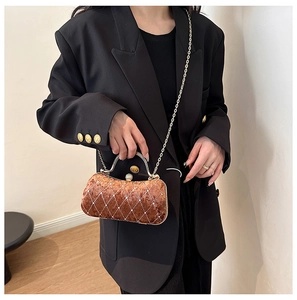 Detail of velvet evening bag with rhinestone lattice, metal handle, and chain strap