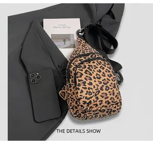 Détail du sac bandoulière léopard sur un blazer avec un smartphone pour comparer la taille