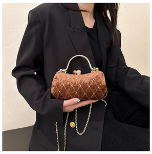 Detail of a brown velvet evening bag with silver rhombus patterns and a gold metal handle