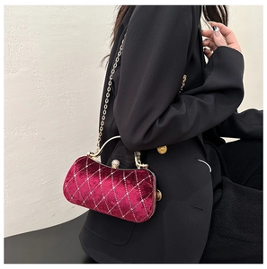 Velvet evening bag in burgundy with diamond-encrusted latch shown on model with chain strap