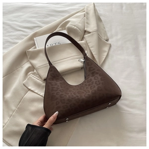 Detailansicht der Hobo-Tasche mit Leopardenmuster, Silber-Reißverschluss und Bodenfüßen