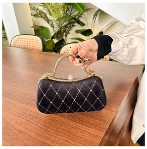 Detail of velvet evening bag with rhinestone lattice pattern and golden top handle