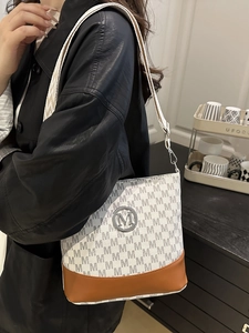 Sac seau gris imprimé avec bordure en cuir marron et large bandoulière tissée chic