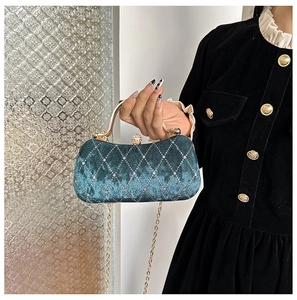 Detail of emerald velvet evening bag with diamond lattice pattern and metallic handle