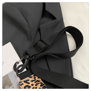Close-up of adjustable black nylon strap with leopard print shoulder pad and matte metal hook