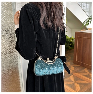 Detail of dark green velvet evening bag with diamond lattice and crystal clasp