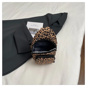 Detail view of leopard print canvas bag with three zipper compartments and compact structure