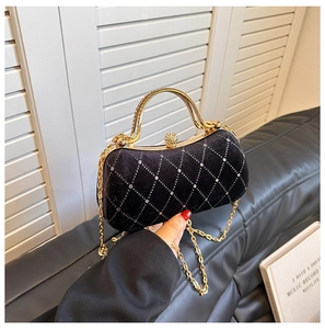 Close-up of velvet evening bag with rhinestone grid pattern and gold spherical clasp