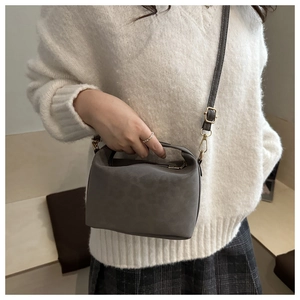 Chic leopard print crossbody bag with top handle shown on model in a cozy white sweater