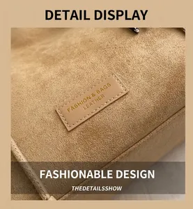 Close-up of suede tote bag featuring a leather patch with embossed fashion branding text
