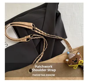Detail of a brown suede bag featuring a stylish leather and gold chain patchwork strap
