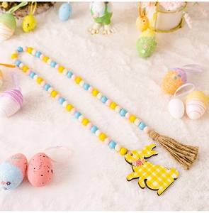 Easter bead garland detail with bunny pendant and jute tassel on white plush background