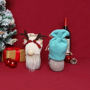 Christmas gnome dolls with knitted hats and antlers on a festive red background
