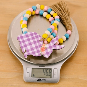 Close-up of Easter beaded garland with rabbit pendant on scale weighing 46.8 grams