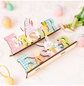 Detail of wooden Easter letters with rabbit and egg motifs on a white plush surface